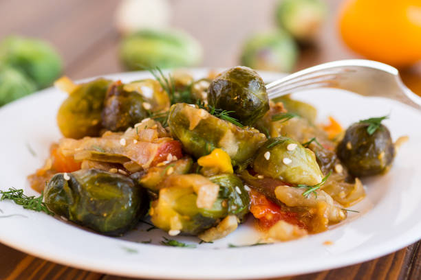 istock Brussel sprouts cooked with vegetables, on a wooden table 2187405402