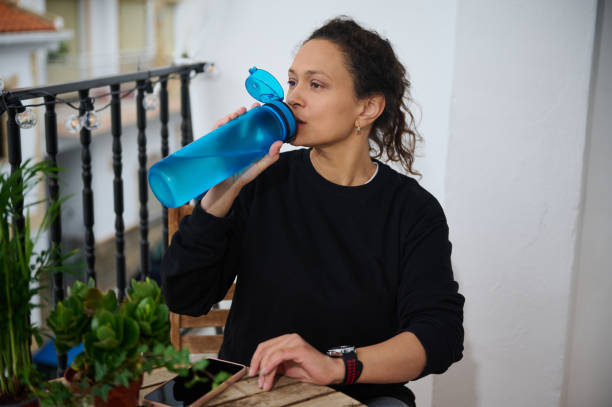 istock Woman drinking water from a bottle on a balcony 2187408572