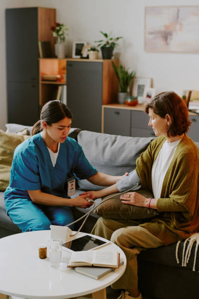 istock Nurse Administering Blood Pressure Check for Elderly Woman 2187410075