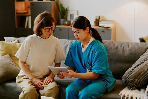 istock Caring Nurse Assisting Elderly Woman with Digital Tablet 2187410125