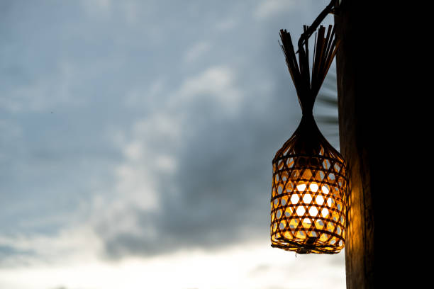 Lamp hanging from woven bamboo in the dusk
