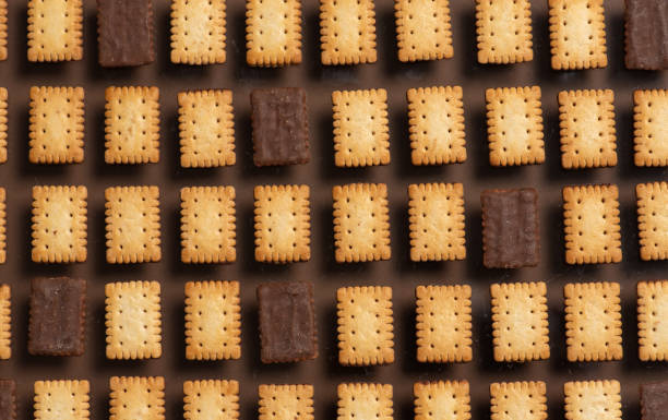 istock Grid of square crackers arranged on brown background 2187411103