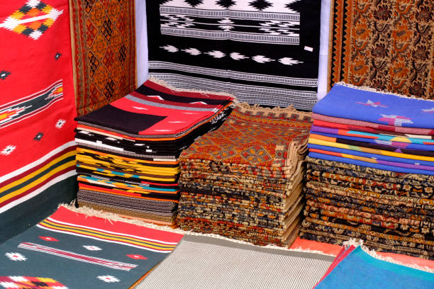 istock Stack of multicolored quality rugs at carpet shop, Carpets variety selection rolled up rugs shop store. 2187412514