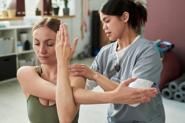istock Physical Therapist Assisting with Shoulder Stretching Exercise 2187415958