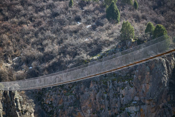istock Excursion suspension bridge over gorge, Kyrgyzstan. Crossing between mountains 2187418628