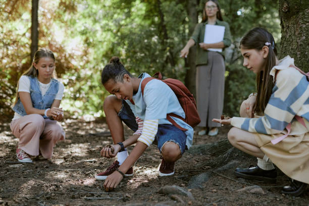 istock Teenagers Picking Up Pine Cones From Ground 2187421110