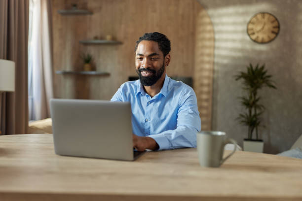 istock Happy black man working on laptop at home. 2187421542
