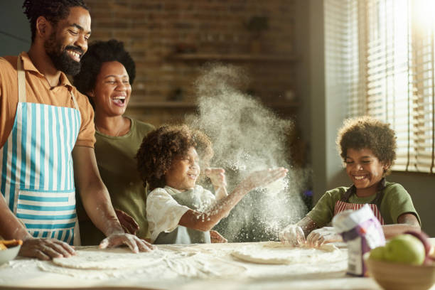 istock Happy black family having fun while making a cake at home. 2187421701