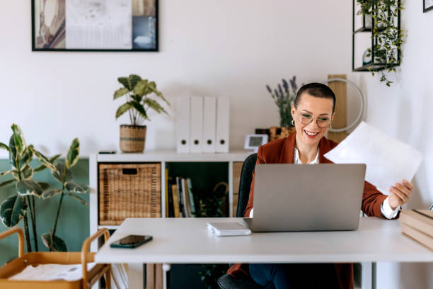 istock Smiling well dressed businesswoman using laptop at the office 2187421850