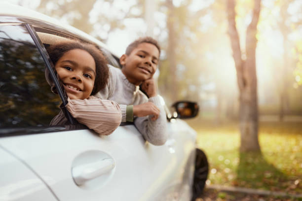 istock Happy black kids enjoying through car window in nature. 2187422824