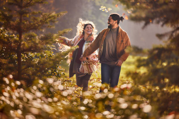 istock Playful diverse couple running during autumn in nature. 2187423043