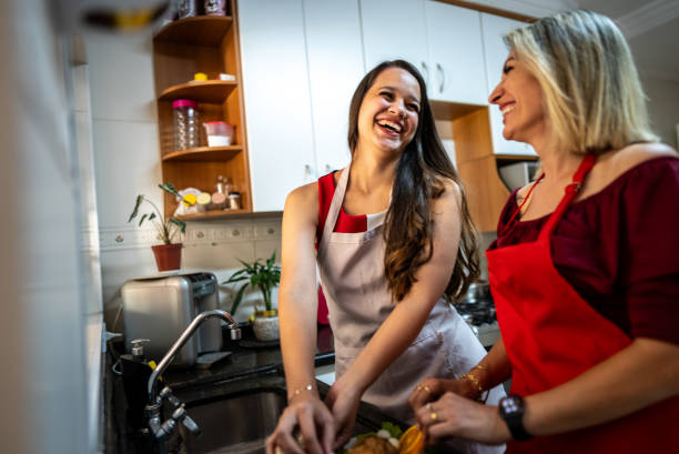 istock Mother and daughter talking and cooking on kitchen at home 2187435342
