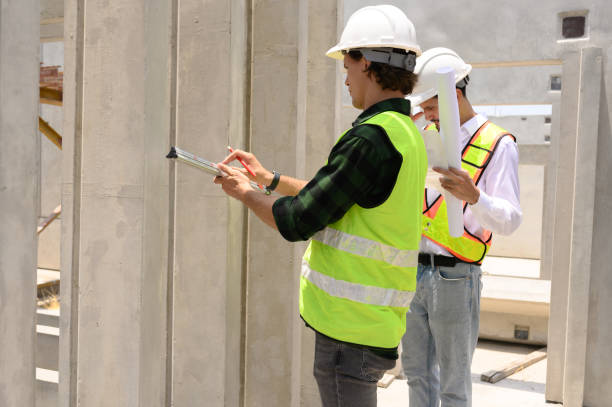 istock Engineers and foremen wearing hard hats in factory. Hard hats talking on construction site. 2187438511