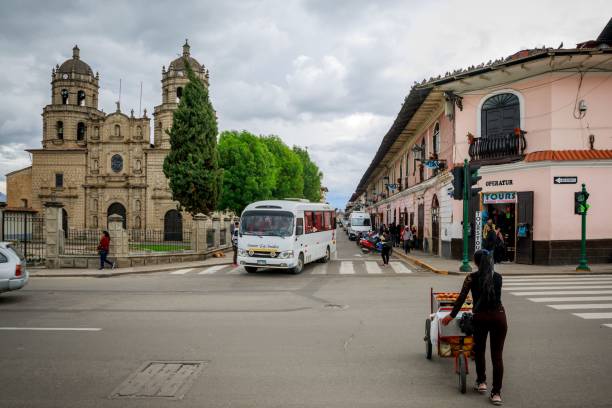 Cajamar, Peru – December 17, 2019: A bustling street in Peru with colorful tuk-tuks and a colonial church