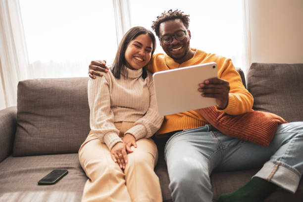 istock Happy couple enjoying tablet while sitting on a cozy sofa 2187441943