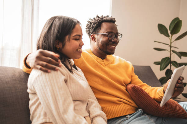 istock Smiling couple relaxing on the sofa watching something together 2187441944