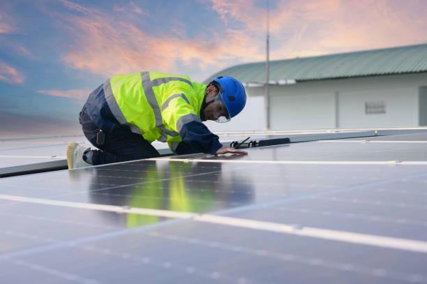 istock Male engineer works installing solar panels on the roof. Engineer or worker working on solar panels or photovoltaic cells on the roof of a business building. 2187445008