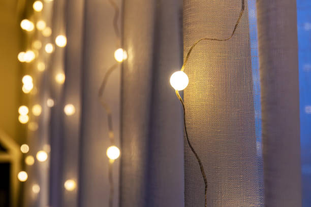 istock Warm, inviting fairy lights illuminate sheer curtains, creating a soft ambiance 2187447971