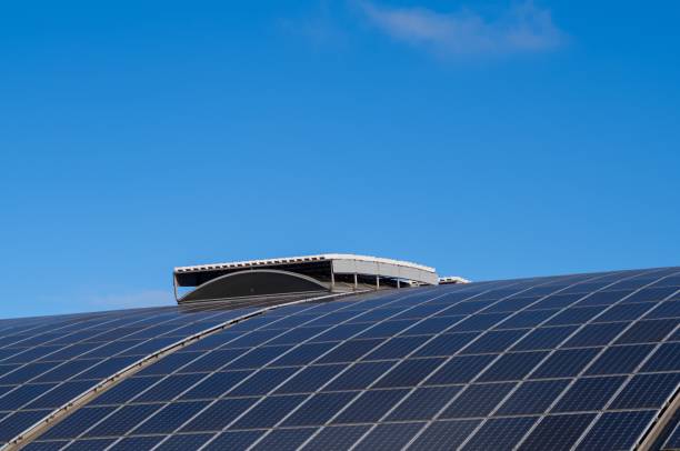 istock Solar panels covering a curved roof under a clear blue sky 2187448351