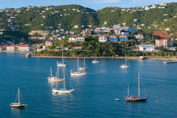 Charlotte Amalie, St. Thomas, U.S. Virgin Islands - January 2, 2018: Sailboats anchored in the harbor with a scenic hillside town in the background.