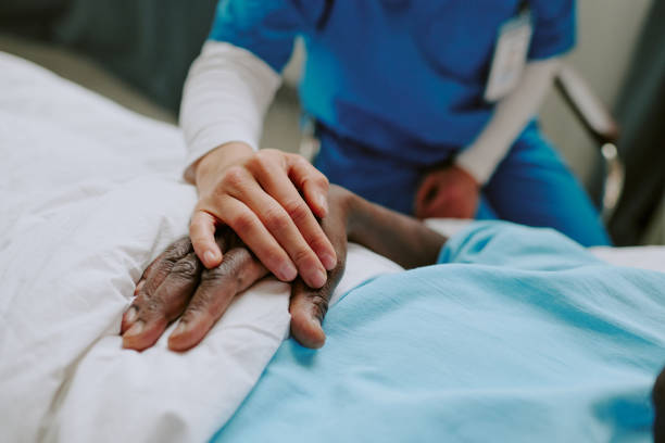 istock Holding Hands at Hospital Bedside with Patient Wearing ID Badge 2187457676