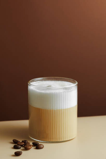 istock cappuccino in glass and coffee beans near on table 2187458385