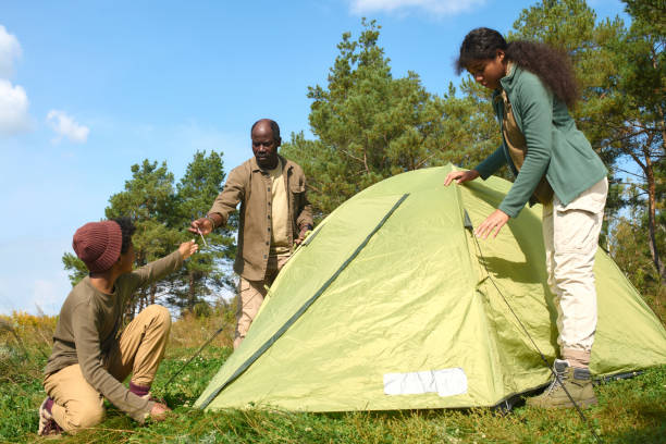 istock Boy Helping Parent and Sister with Tent 2187459016