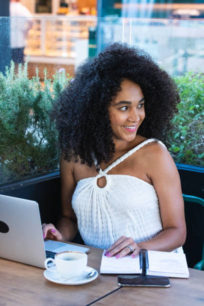 istock Smiling black woman working on laptop in cafe 2187463366