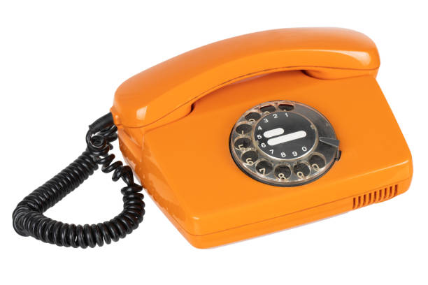 Old vintage orange rotary phone isolated on white background