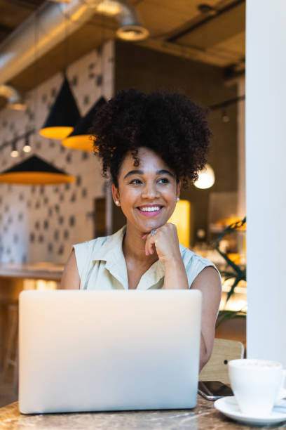 istock Smiling black woman browsing laptop 2187465137