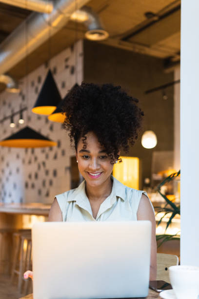 istock Smiling black woman browsing laptop 2187465141