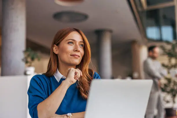 A portrait of a pensive woman sitting at a desk in the office. A portrait of a pensive woman sitting at a desk in the office.