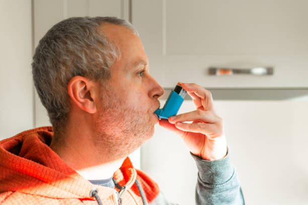 istock Man suffering from asthma using inhaler at home 2187466148