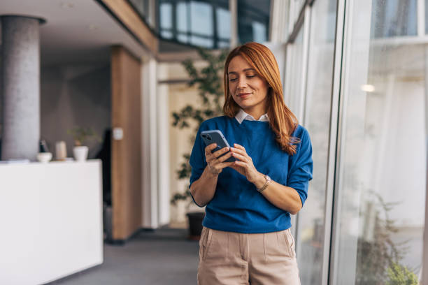 istock A confident businesswoman using smartphone while standing in office corridor 2187467319