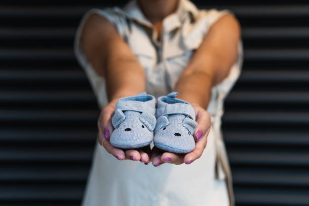 istock Anonymous black woman showing baby booties 2187468094