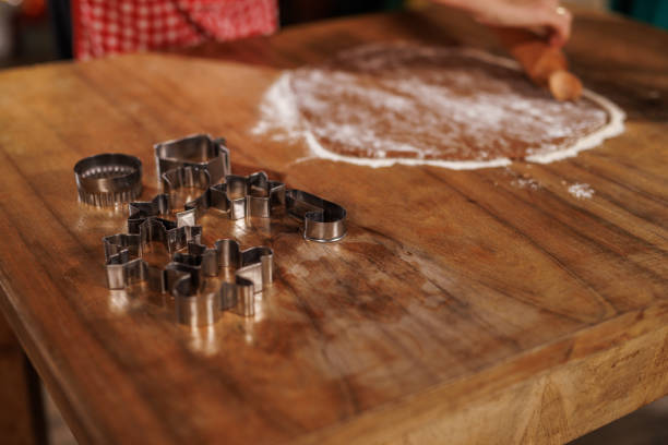 A cozy baking scene with cookie cutters and dough on a wooden table. The atmosphere evokes warmth, creativity, and the joy of homemade holiday treats, perfect for festive family gatherings.