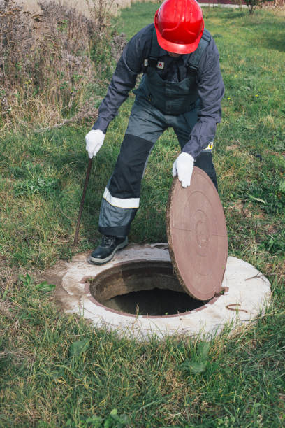 istock Worker opens septic well manhole cover. septic tank maintenance and sewage pumping 2187470083