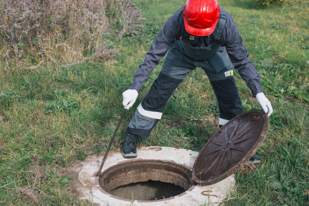 istock Worker opens septic well manhole cover. septic tank maintenance and sewage pumping 2187470084