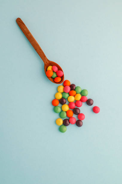 istock Chocolate round candies scattered on a soft blue background 2187470796