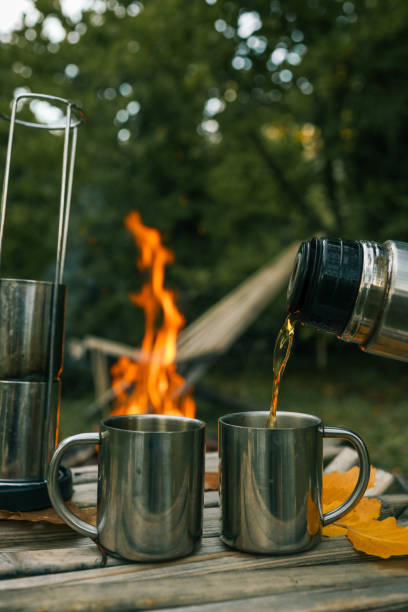 istock Themed trip. The man pours a hot drink into the thermos 2187472382