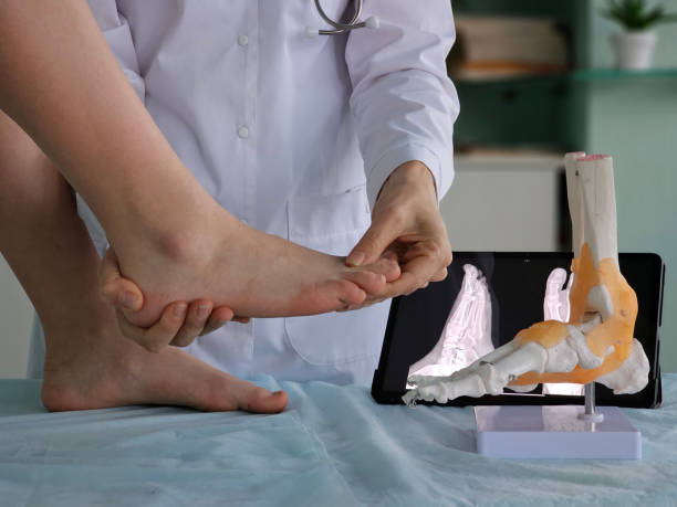 istock A doctor examines a patient's foot using a skeletal model in a clinic 2187473862