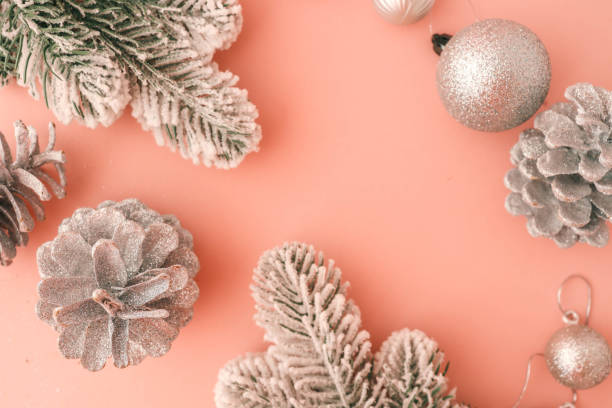 istock Festive Christmas composition featuring snow-covered branches, glittery pinecones, and shimmering ornaments on a pastel pink background. Perfect for holiday greeting cards 2187475835