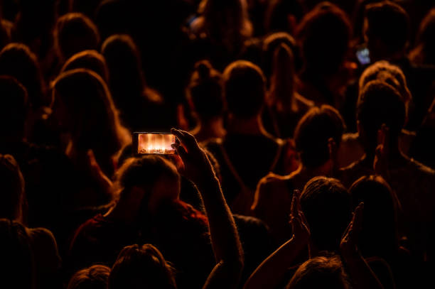 Audience at a concert and a visitor with a smartphone