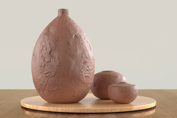A brown vase sits on a wooden table next to two other objects