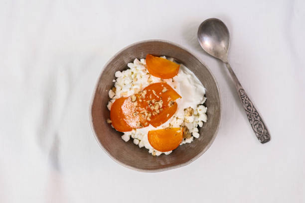 istock Cheese cottage with yogurt and fresh persimmon on white table. 2187476958