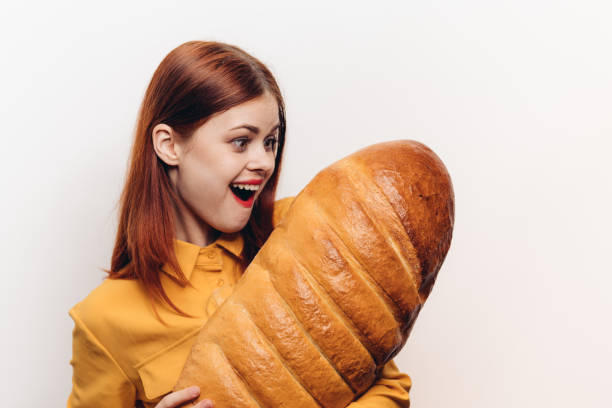 istock surprised woman examines a loaf in her hands on a light background 2187477880