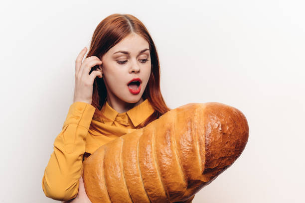 istock interested woman with a large loaf surprised look light background 2187480484