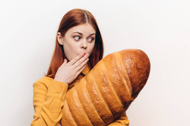 istock surprised woman examines a loaf in her hands on a light background 2187480748