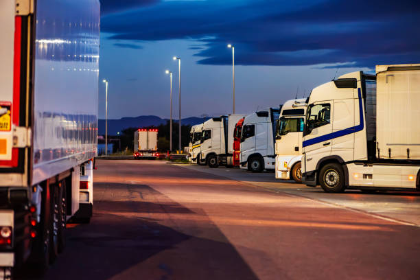 istock Several trucks parked in a motorway car park at night, taking mandatory breaks. 2187485024
