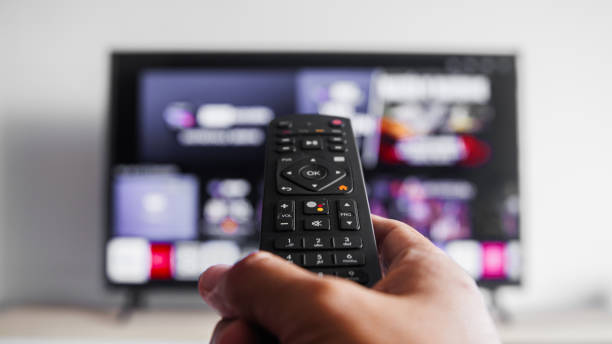 istock A person is holding a remote control in front of a television 2187488678